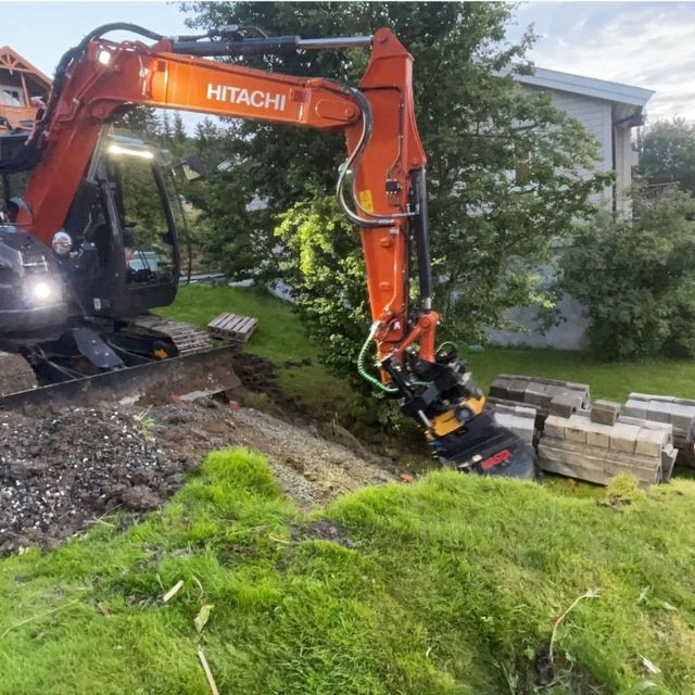 Gravemaskin i arbeid på tomt